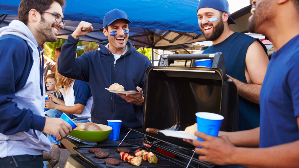 Group Of Male Sports Fans Tailgating In Stadium Car Park