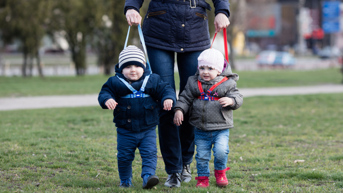 Young mother walking with her two children off the leash