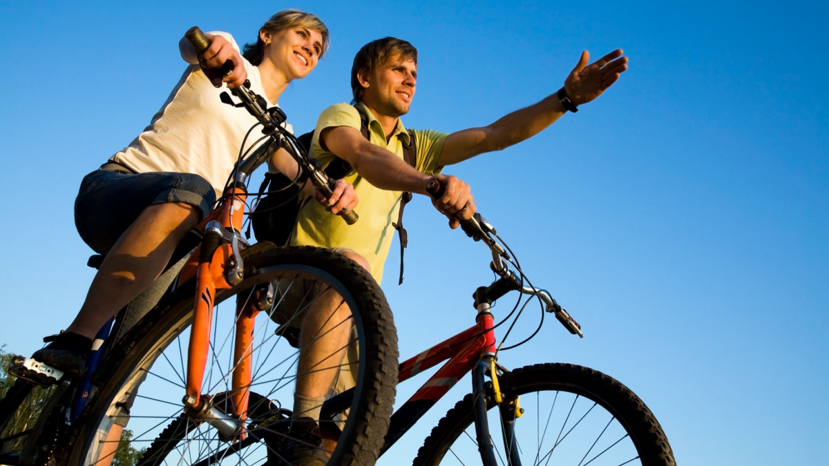 Beautiful Couple on bicycles on the brink of a rock and look afar from rock breakage.