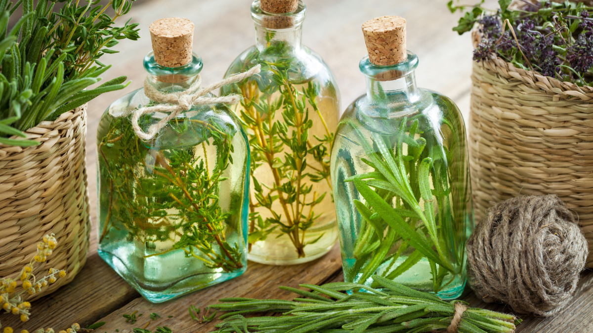 Bottles of thyme and rosemary essential oil or infusion, herbal medicine.