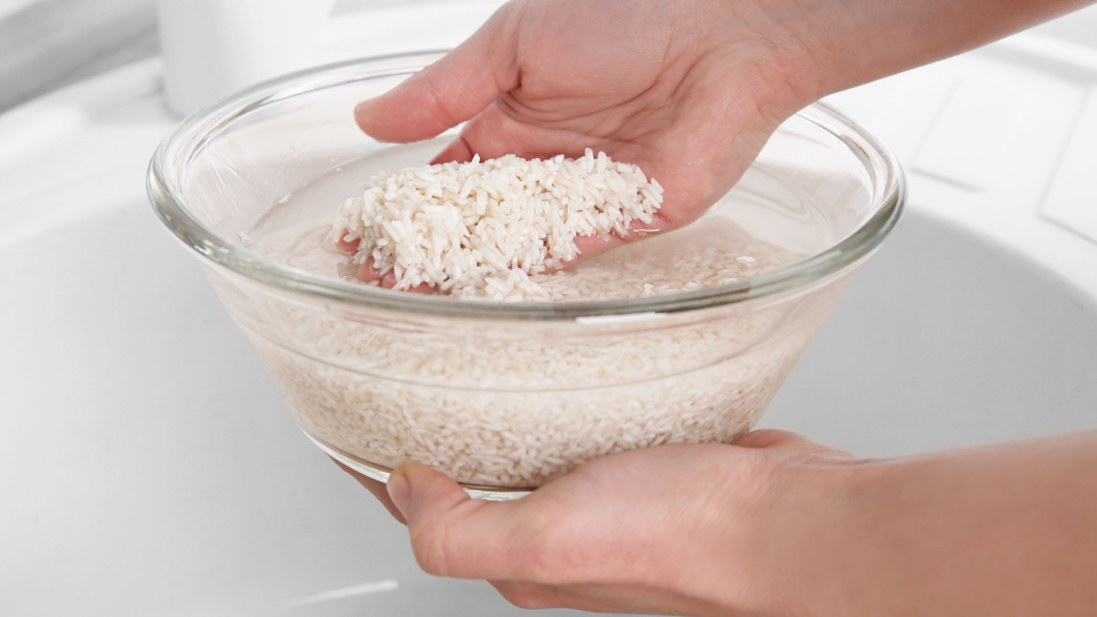 8 Products Frugal People Always Buy In Bulk 9 Woman rinsing rice in glass bowl with water