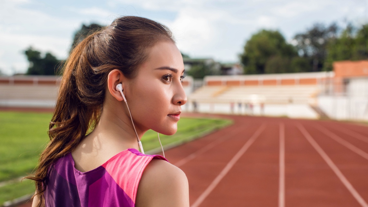 Fitness girl with sport in-ear wireless headphones.