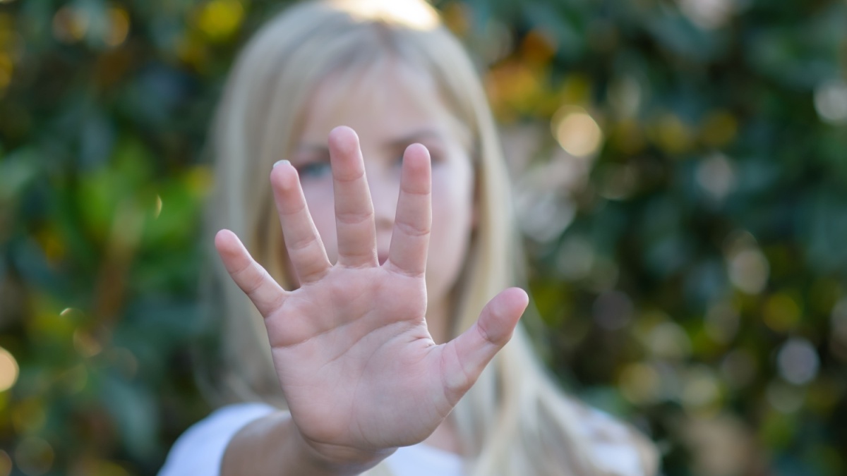 Back away sign from young girl palm of hand.