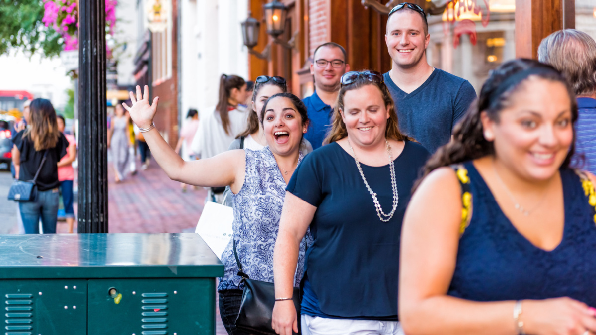 Happy young students walking in evening in downtown Georgetown neighborhood and brick buildings, stores