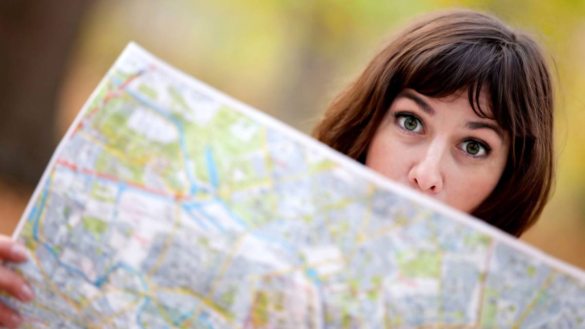 Lost woman in the countryside holding a map.