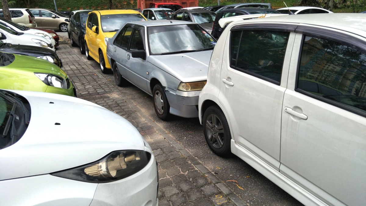 Cars double park blocking pathway of other cars inside the parking.