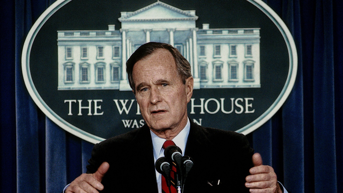 President George H.W. Bush talks with and answers reporters questions during a press briefing in the White House Press briefing room.