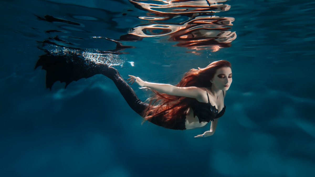 Underwater red hair freediver girl with mermaid tale