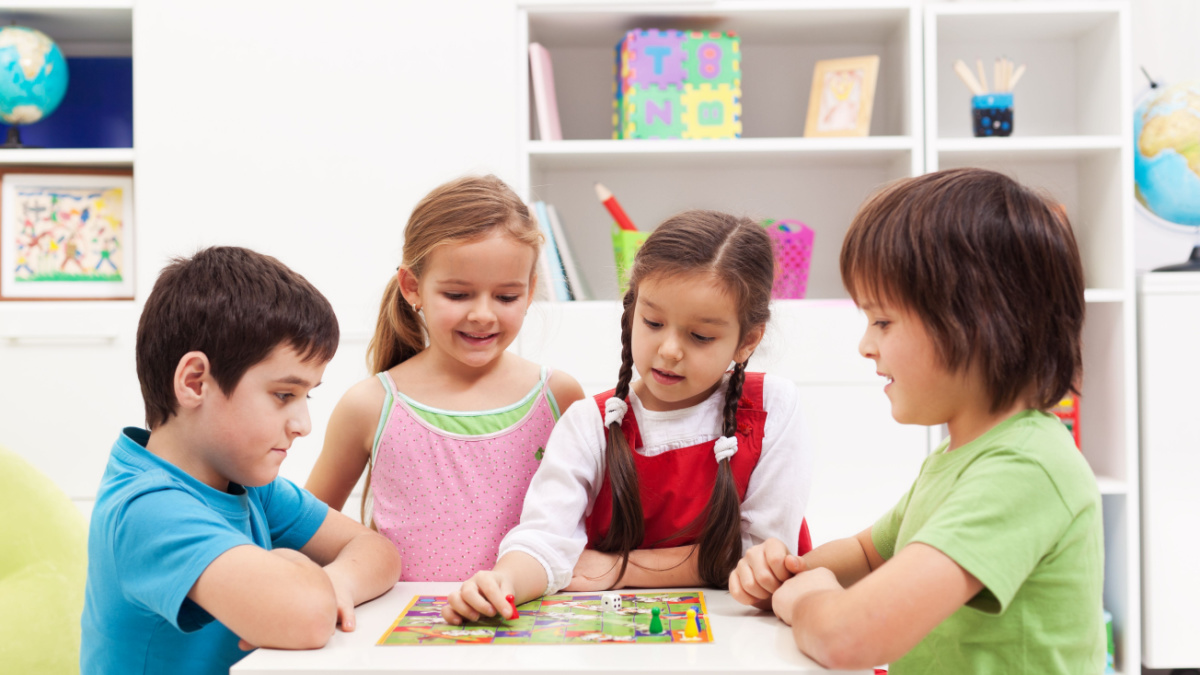 Four kids playing board game in their room