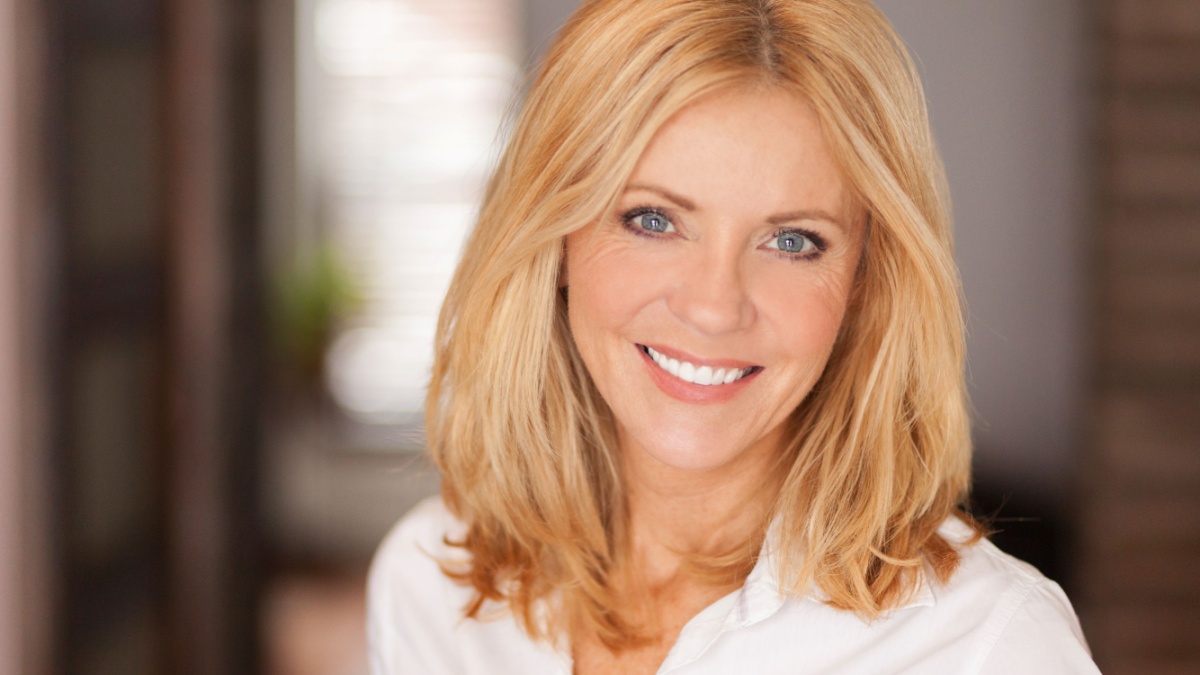 Mature woman smiling at the camera. She relaxing at home. Beautiful.