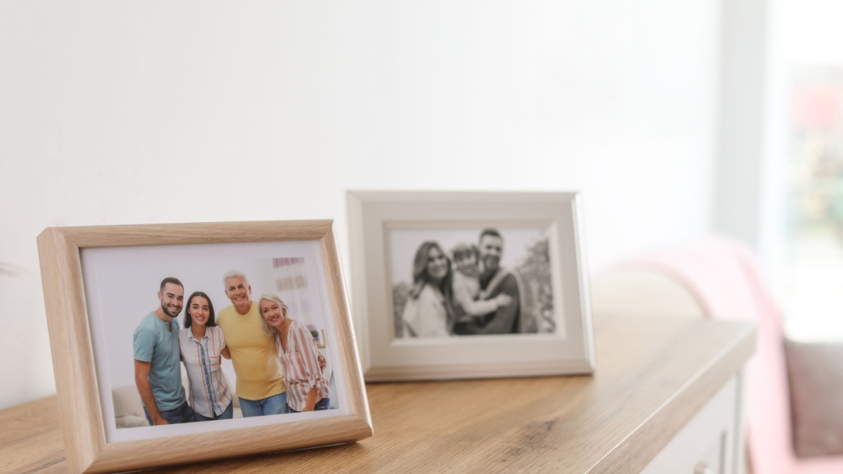Family portraits in frames on cabinet indoors