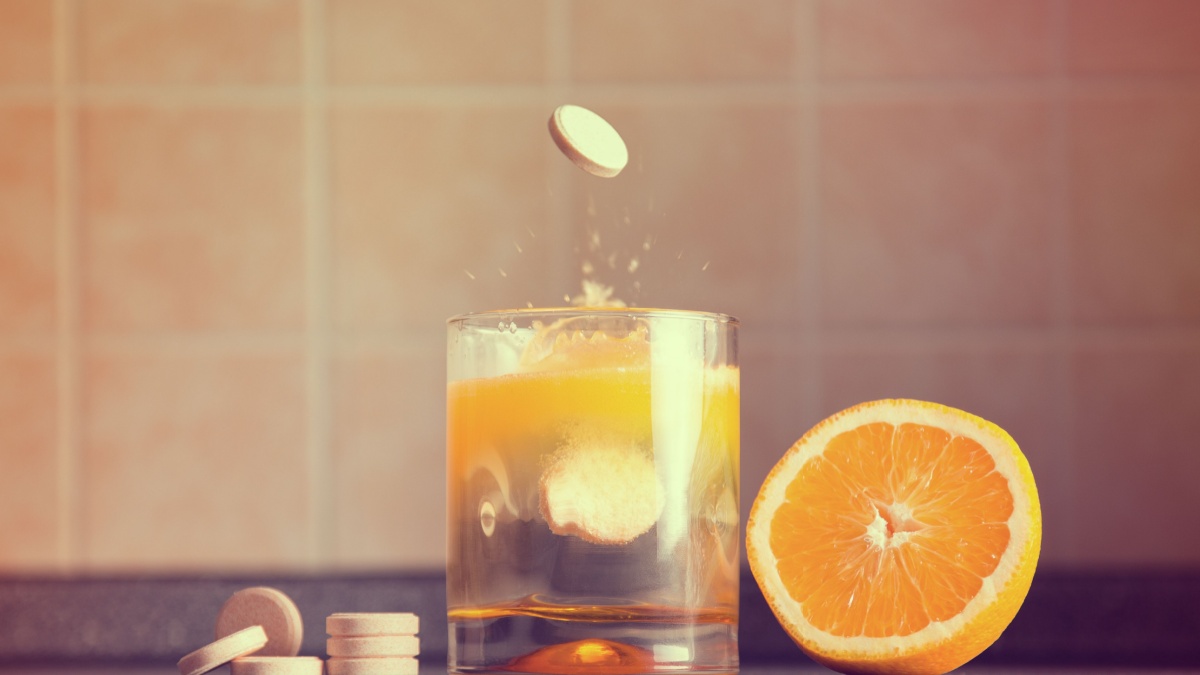 Artistic shot of vitamin C family, orange, tablet stack, dissolving tablet