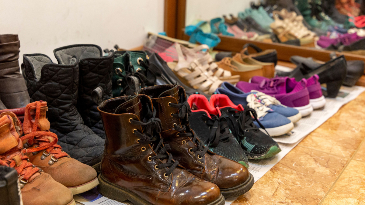 A lot of different used old shoes are laid out on the floor in the hallway. Storage Organization Concept.