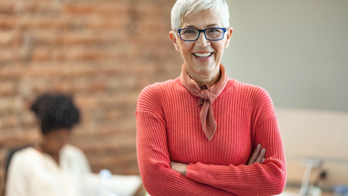 Portrait of mature business woman standing at office.