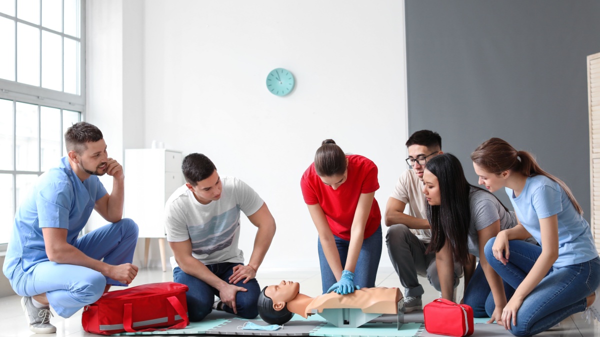 Instructor demonstrating CPR on mannequin at first aid training course