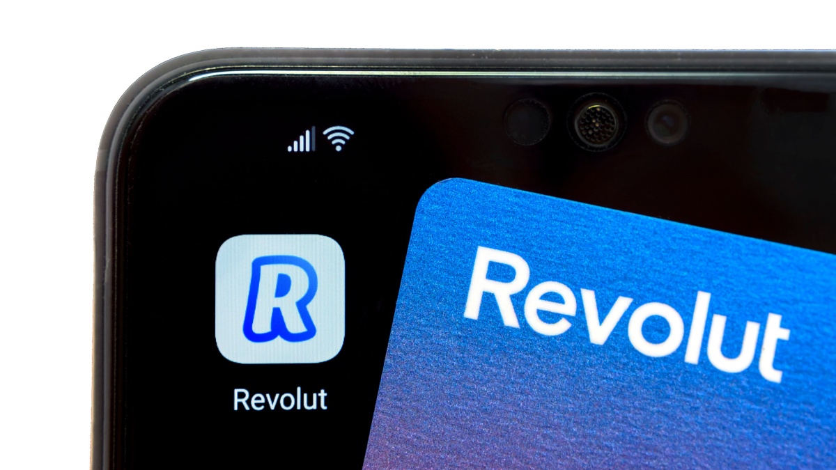 The new redesigned Revolut card placed on top of smartphone with Revolut app. Concept for mobile banking.