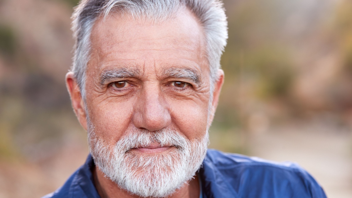 Outdoor Portrait Of Serious Hispanic Senior Man With Mental Health Concerns.