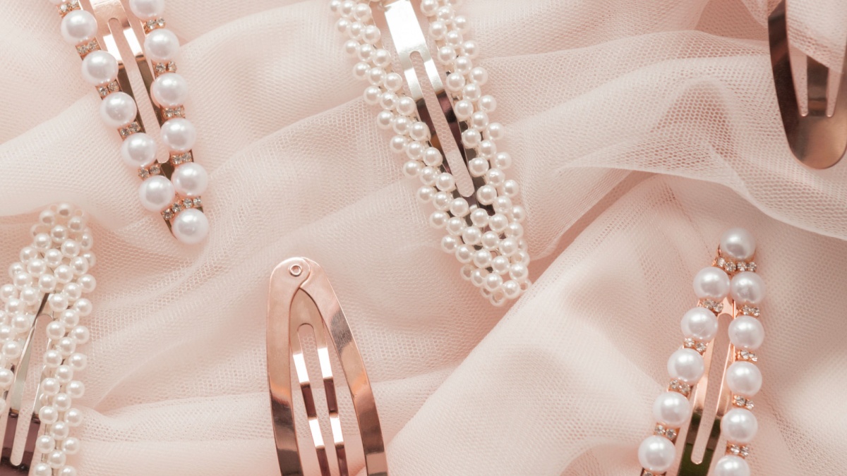 hair accessories trend concept pattern of hair clips with pearls on pink tulle background