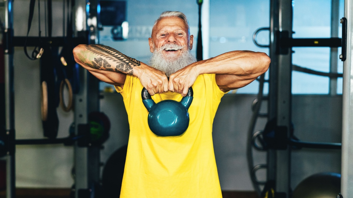 Hipster senior man training inside gym.
