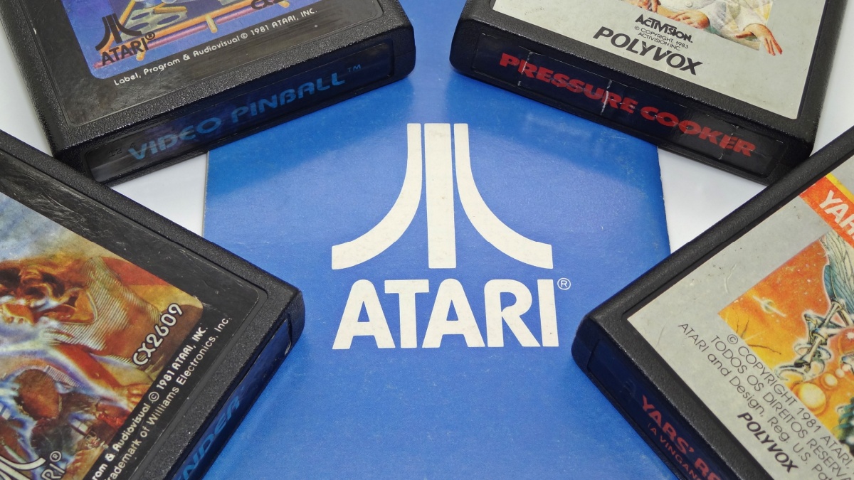 Several Atari 2600 cartridges and a blue catalog with the company logo.