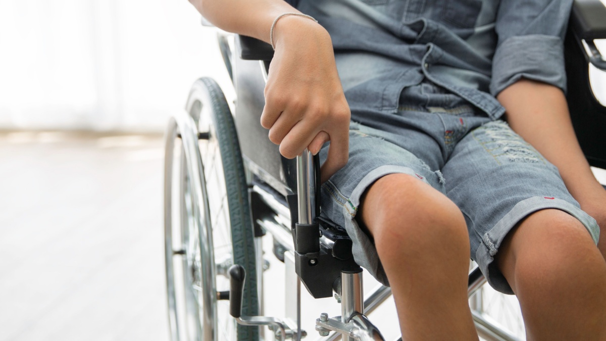 Disability polio patient sitting on wheelchair in hospital.