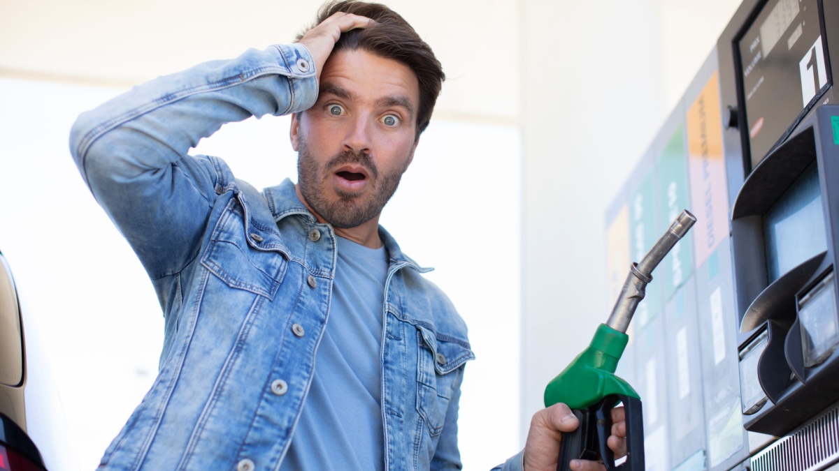 emotional businessman counting money with gasoline refueling car.