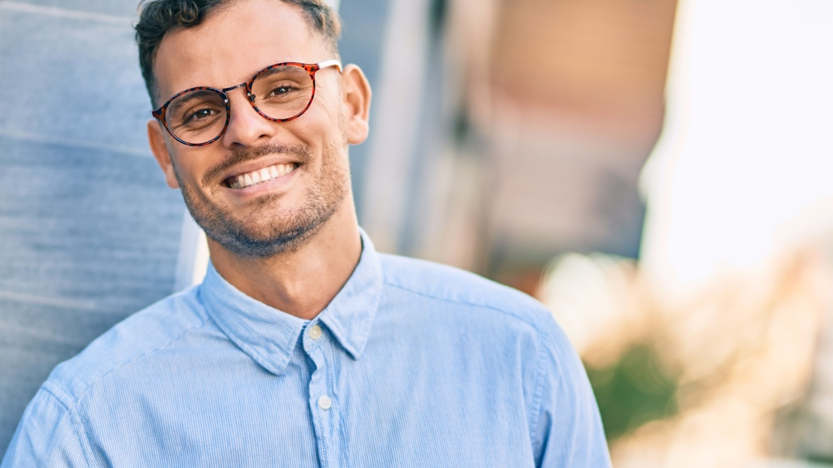 Young hispanic businessman smiling happy standing at the city.