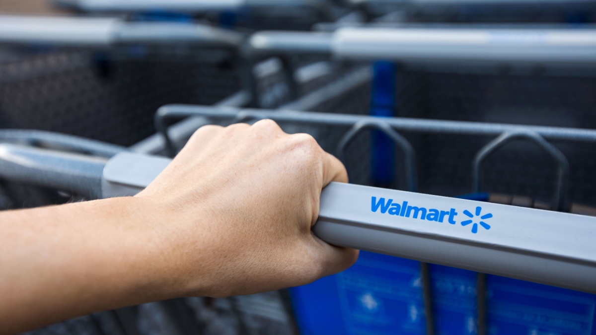 Cancun, Mexico, 9 February 2016: Woman taking shopping cart near supermarket Walmart. Closeup on female hand holding shop trolley with sign of the shop.