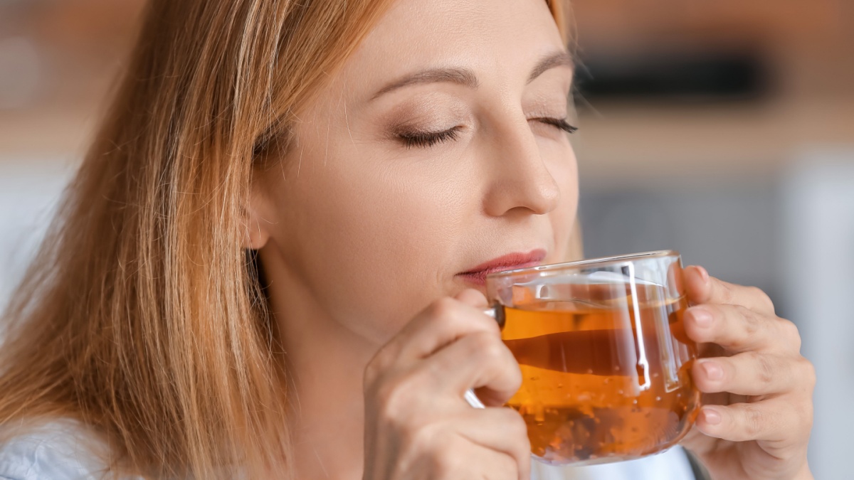 Beautiful woman drinking tea at home.