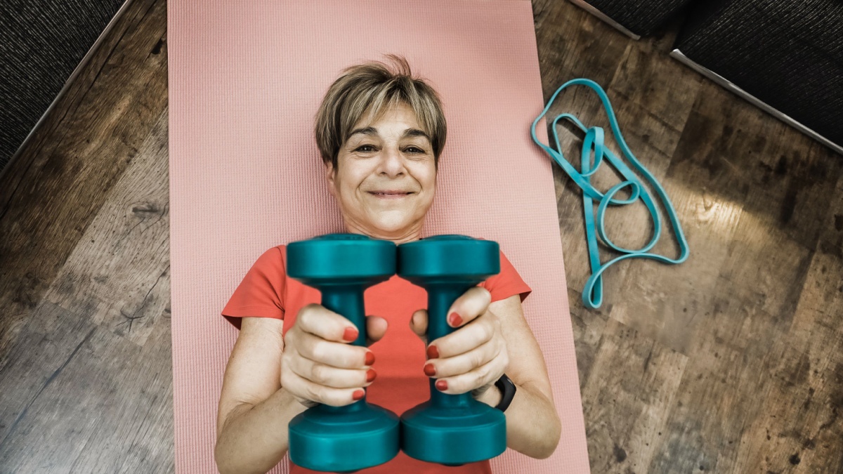 Senior woman doing workout routine t home - Elderly sport and healthy lifestyle - Focus on face.