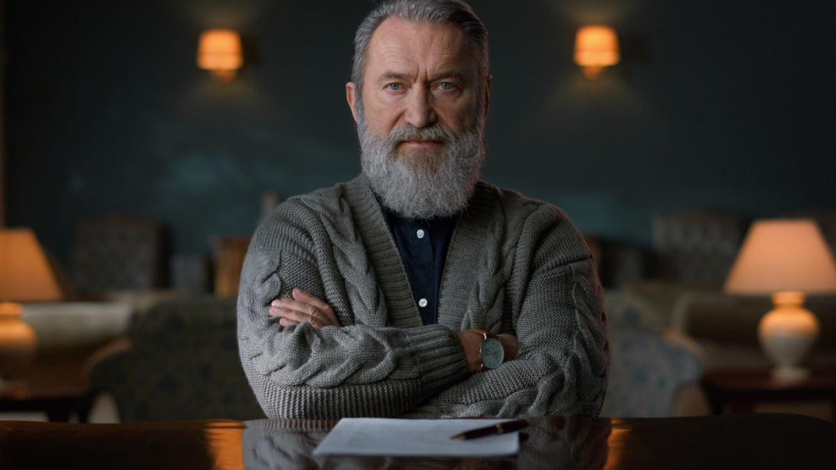 Old man portrait in classic interior. Serious elderly man posing camera at home. Closeup business man sitting at home workplace.
