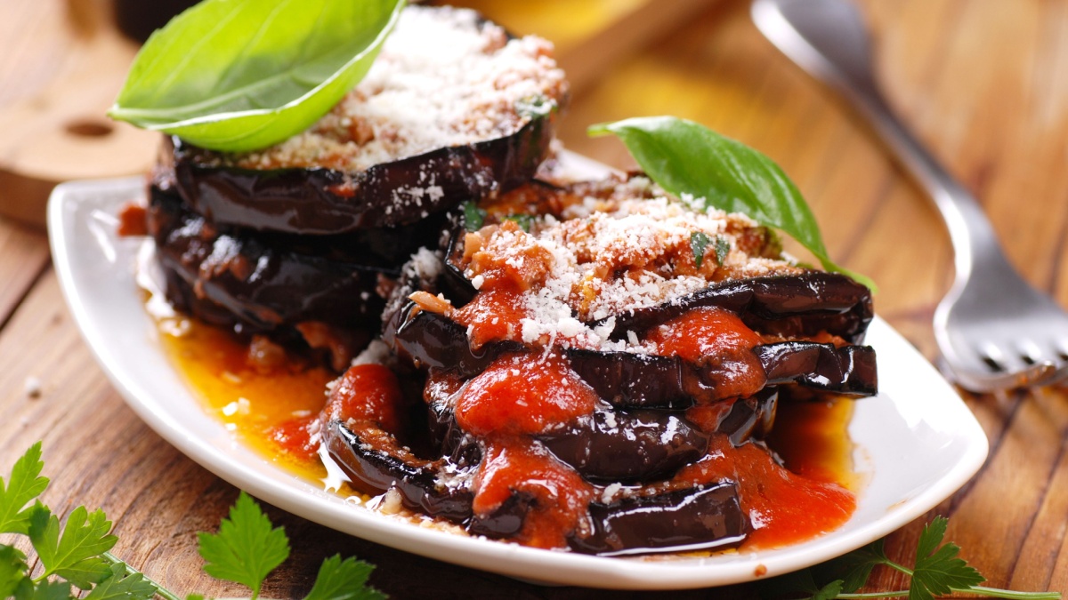 eggplant parmesan decorated with basil leaves
