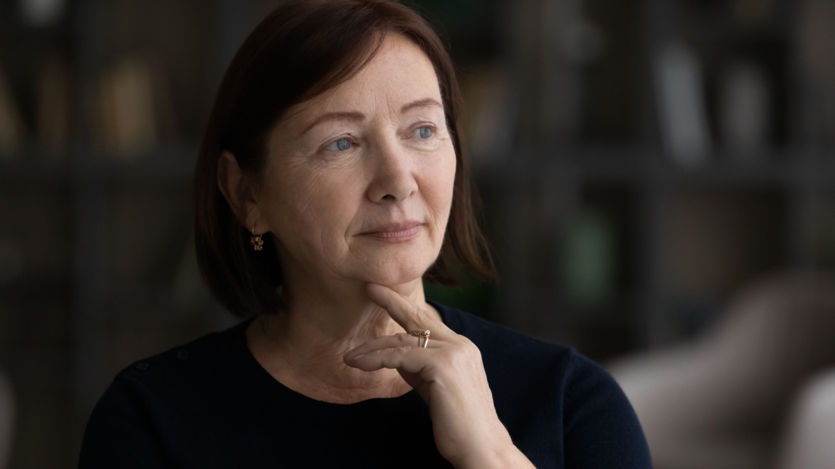 Head shot close up thoughtful melancholic mature woman looking to aside, feeling sad and lonely, pensive upset senior female lost in thoughts.