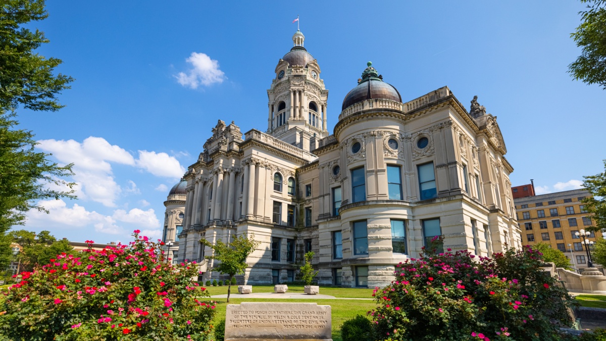 Evansville, Indiana, USA - August 24, 2021: The Vanderburgh County Courthouse with a bench as Civil War Memorial