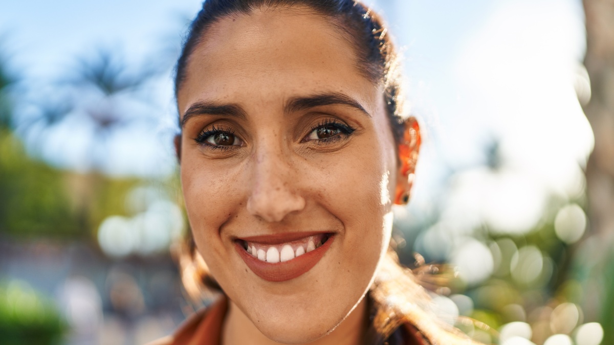 Young hispanic woman smiling confident standing at street.