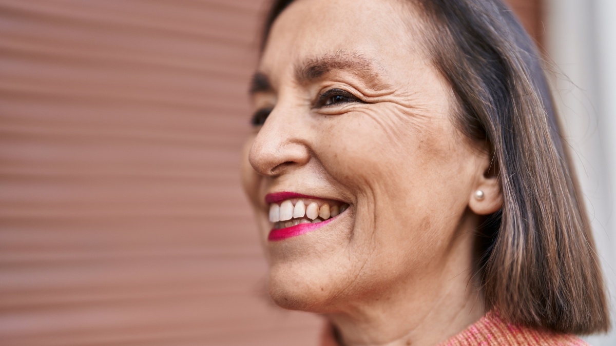Middle age woman smiling confident standing at street.