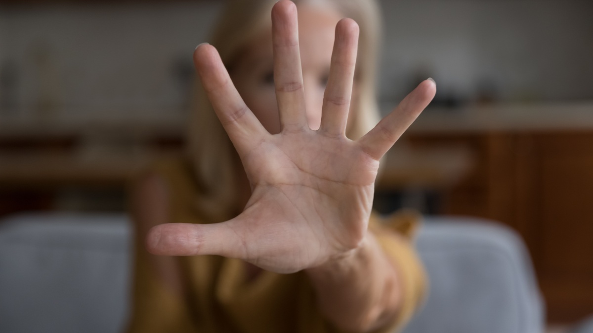 Close up focus unrecognizable older female show palm to cam, stretched her hand to camera makes stop gesture, say no.