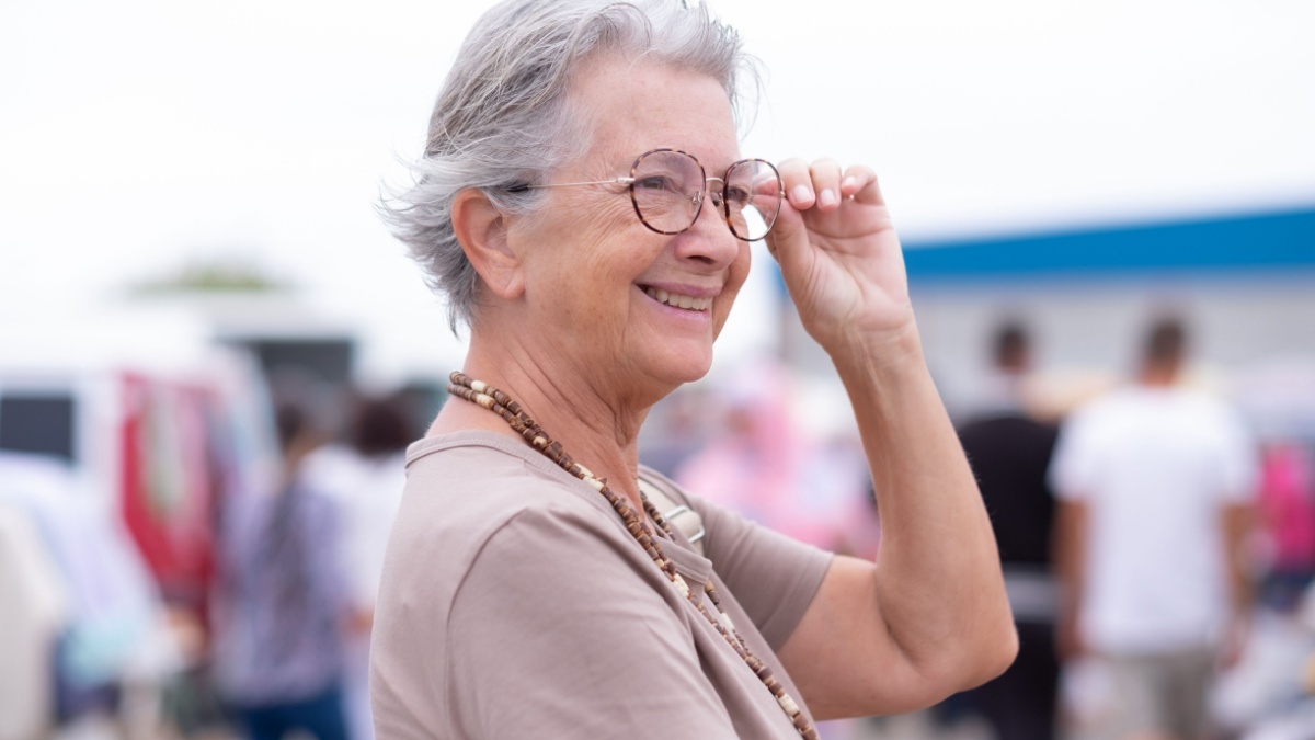 Portrait of smiling senior woman at the flea market looking for second hand clothes, shoes, bags, jewellery..