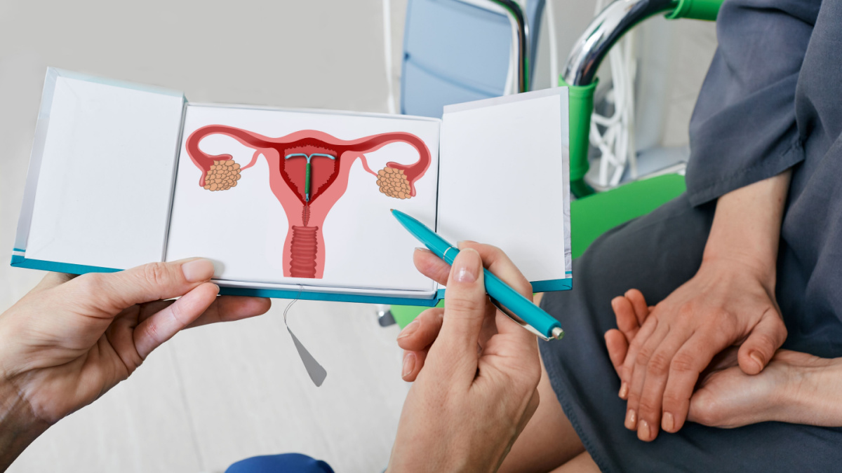 IUD. Experienced gynecologist showing female patient intrauterine contraceptive device or coil to prevent pregnancy while consultation