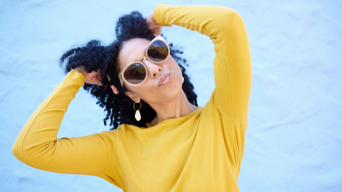 Fashion, sunglasses and black woman with kiss face, summer style and beauty with hairstyle on blue background.