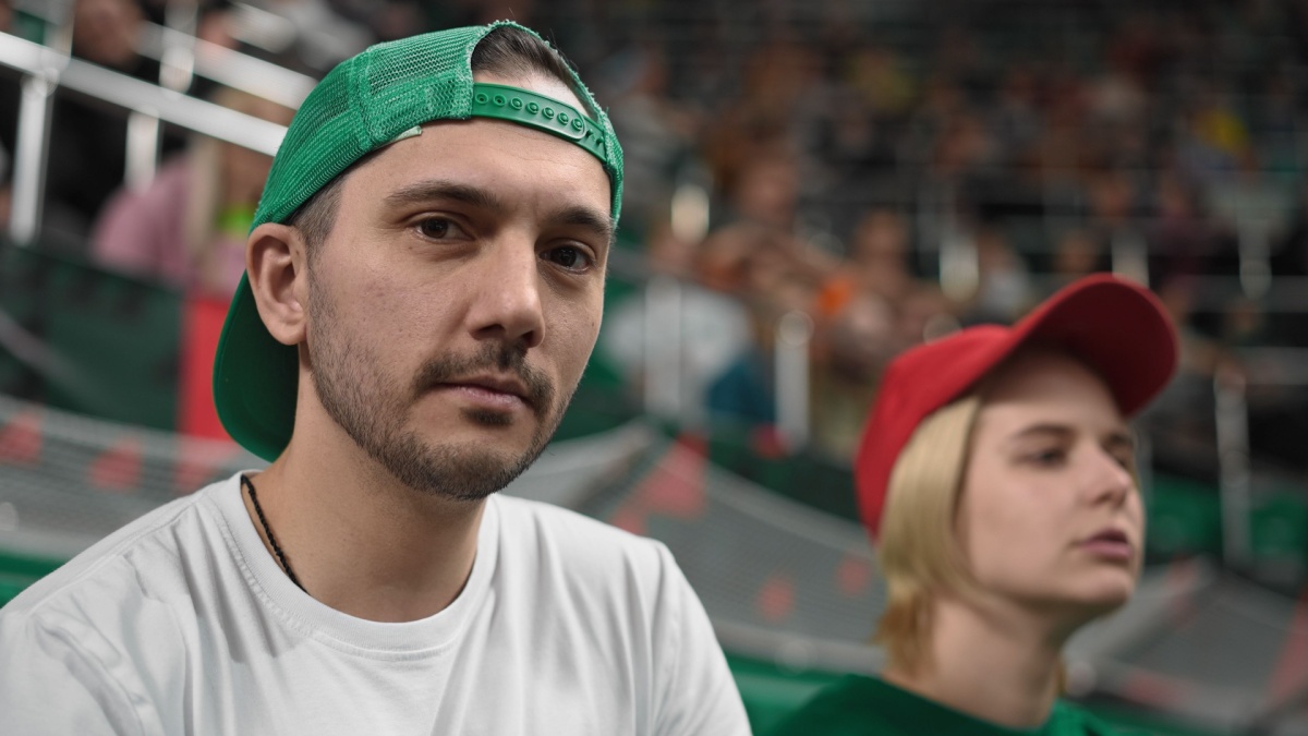 Fan man portrait football sport stadium. Handsome guy look camera soccer tribune. Serious male face close up. Person gaze stare into soul. Cap people.