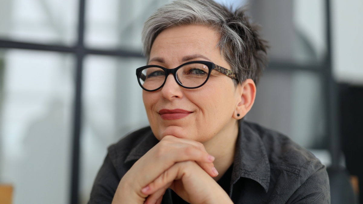 Close-up portrait of a senior smiling woman in glasses.