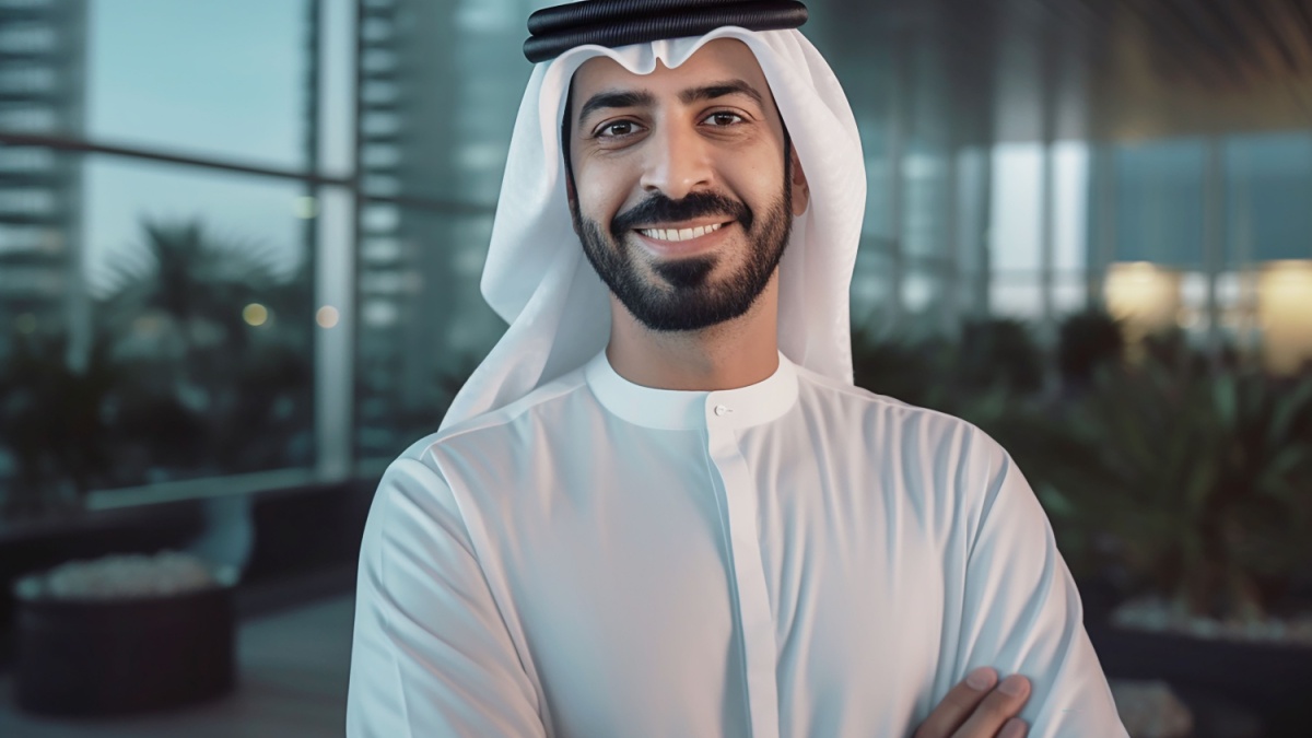 Happy Emirati Arab at office wearing Kandura looking at front ideal for Middle East business concept