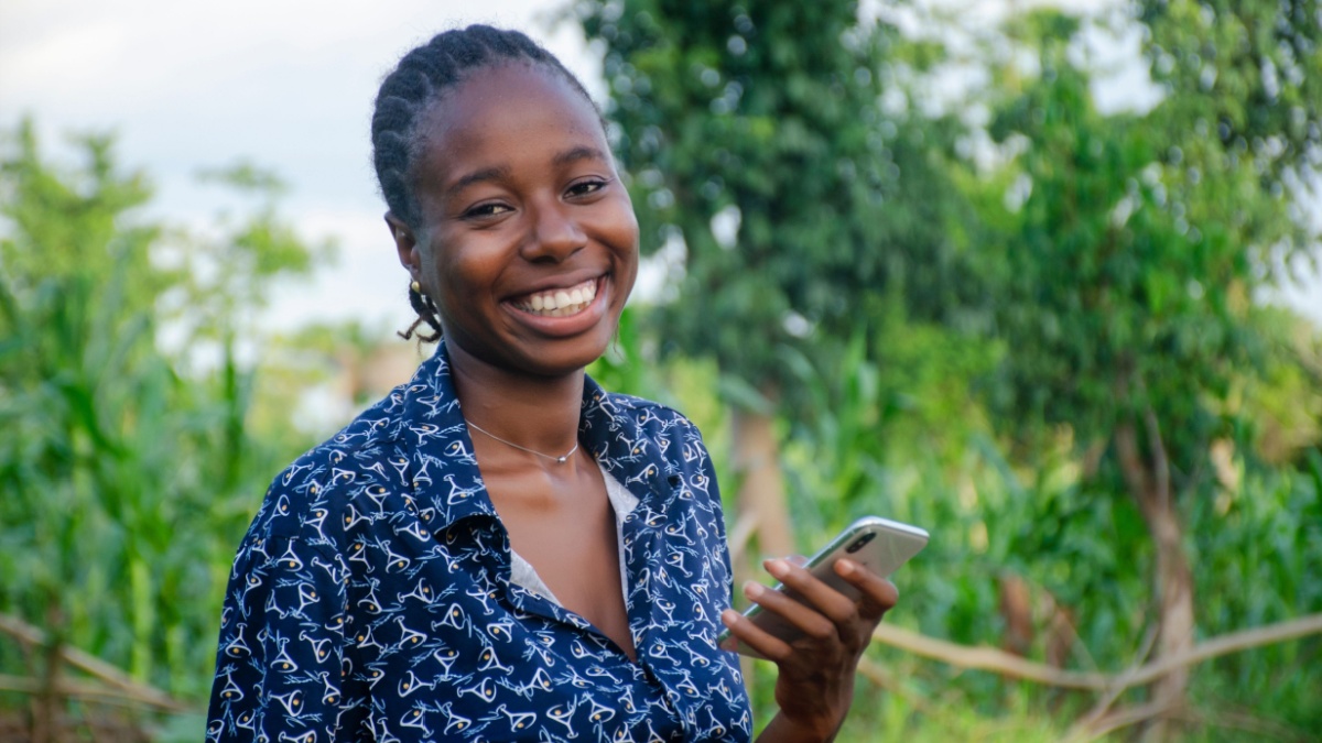 beautiful african farmer happy with the news she saw on her phone.