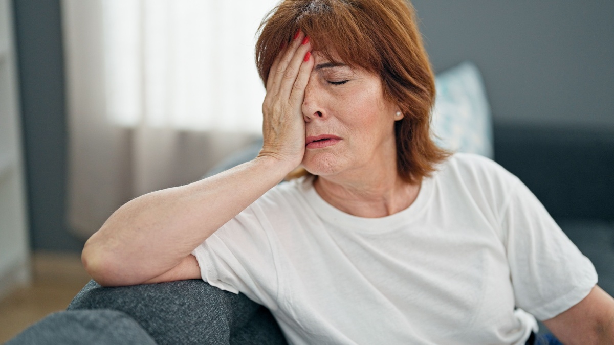 Middle age woman stressed sitting on sofa home.