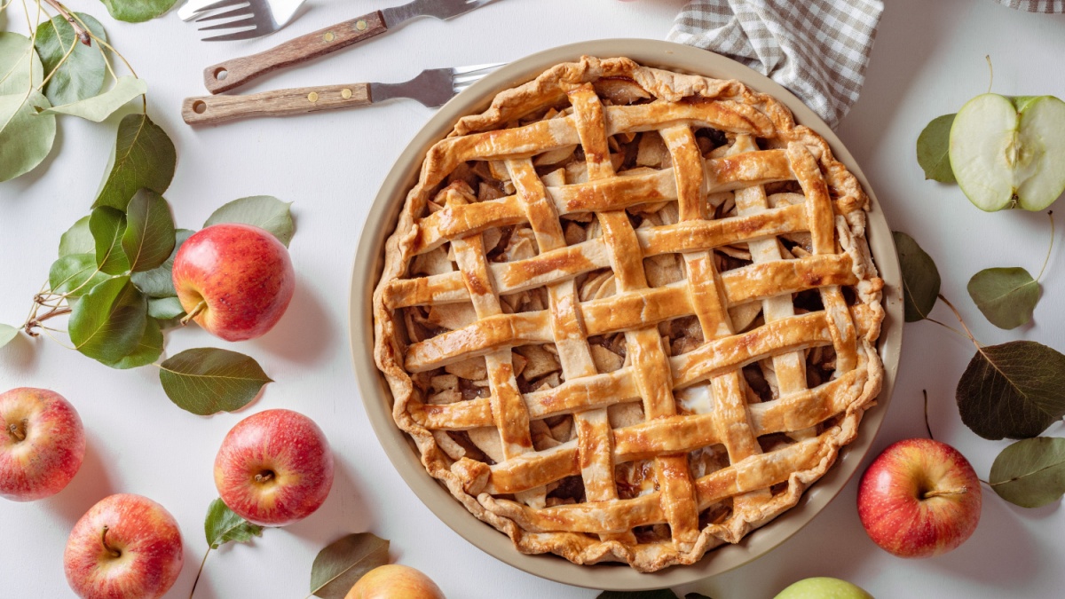 Homemade Apple Pie with fresh apples on white kitchen table, top view, flat lay. Thanksgiving traditional dessert, Thanksgiving tart preparation, autumn bakery.