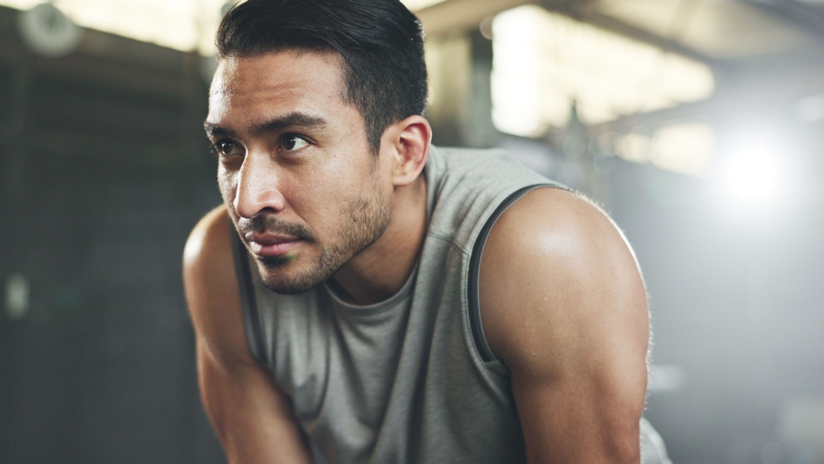 Sweat, fitness and man tired from gym, workout or rest in training in cardio, sports and body builder breathing with fatigue.