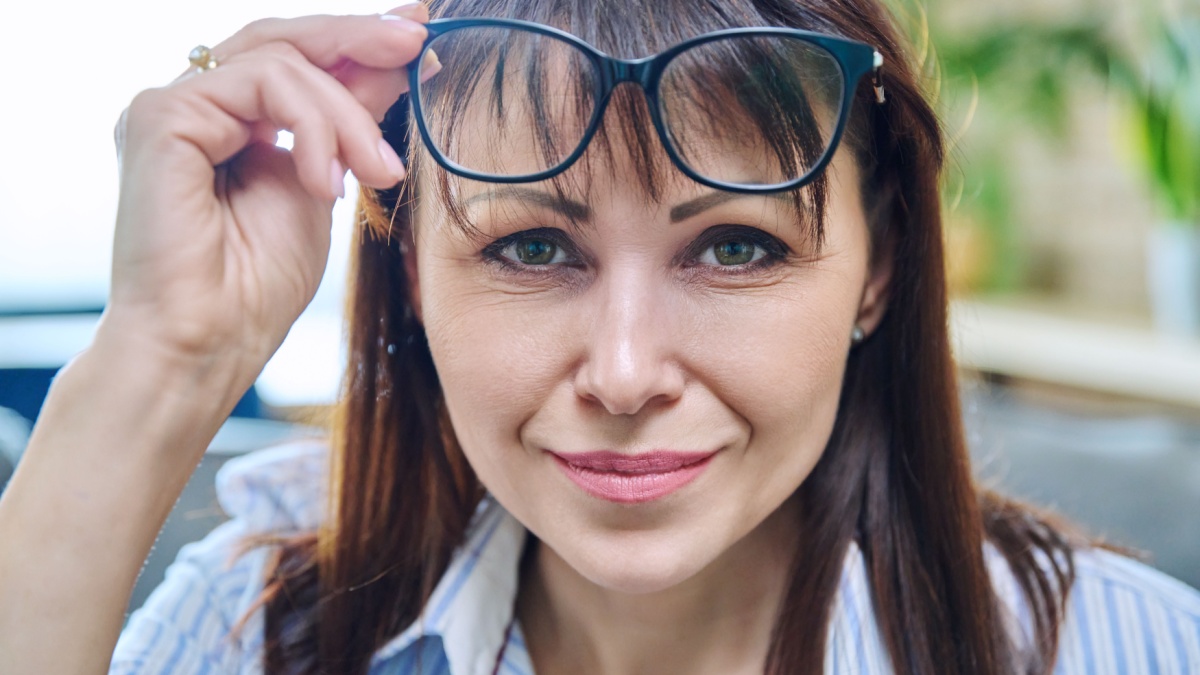 Close-up of the face of mature woman in glasses, an attentive looking look.