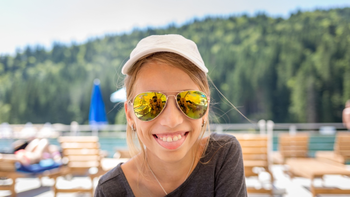 Young teenage girl having fun with her family on a beach vacation. The girl is having fun and sticking her tongue out at the camera.