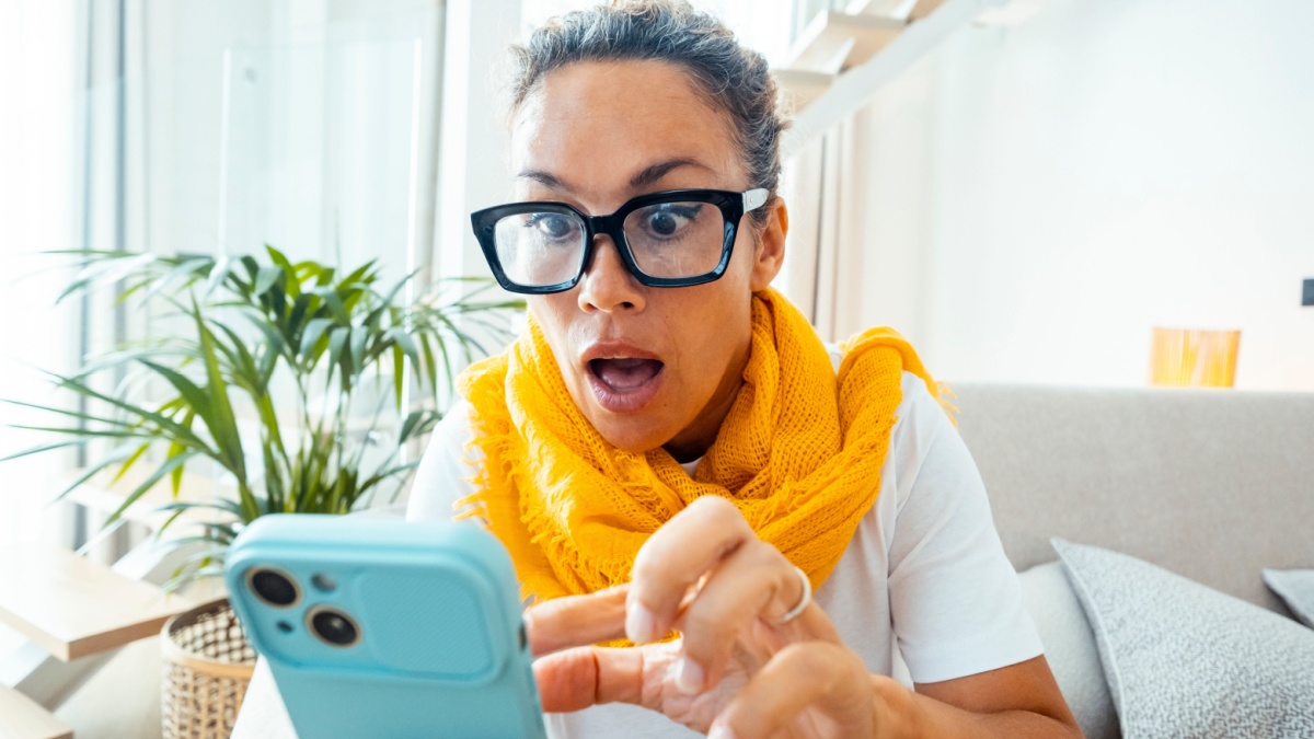 Astonished and surprised expression of woman using mobile phone.